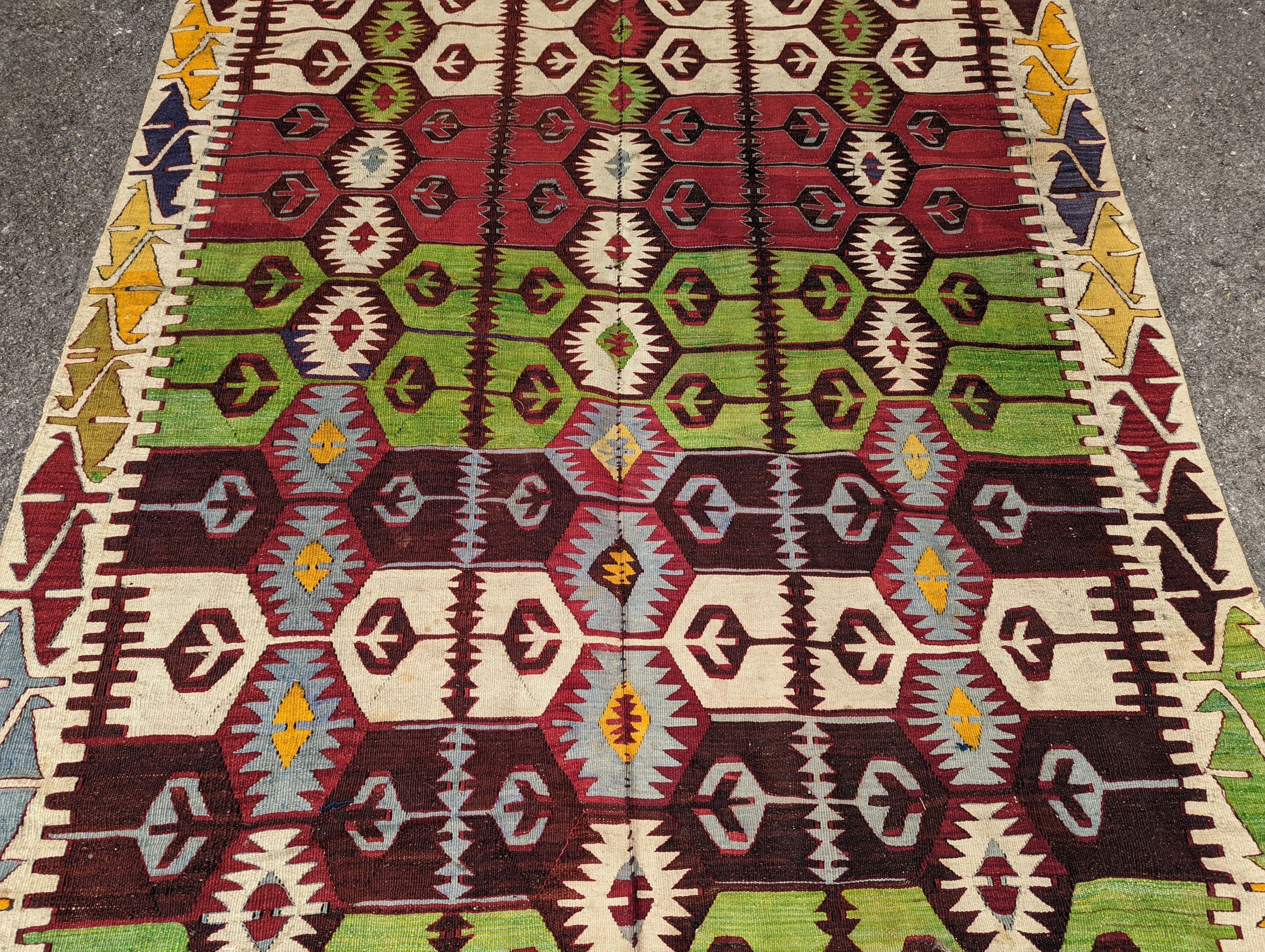 A Kelim polychrome flatweave carpet , cut centrally and re stitched, 425 x 163cm